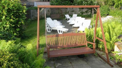 a swing in a garden with a bunch of white chairs at Hotel Hoxter Am Jakobsweg in Höxter
