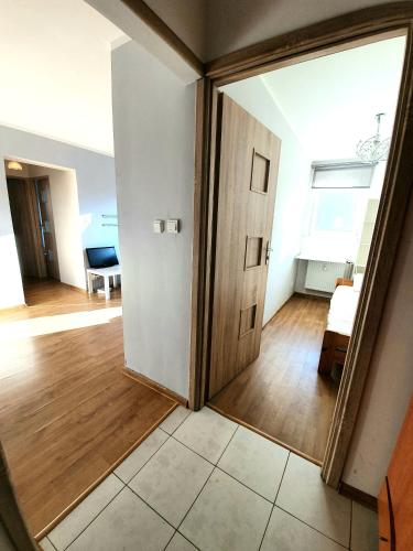 a hallway with a door and a room with wood floors at Apartament Gdańsk Wszędzie blisko , wysoki parter in Gdańsk