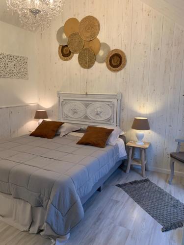 een slaapkamer met een groot bed met 2 tafels en een kroonluchter bij B&B Silentium in Tielt