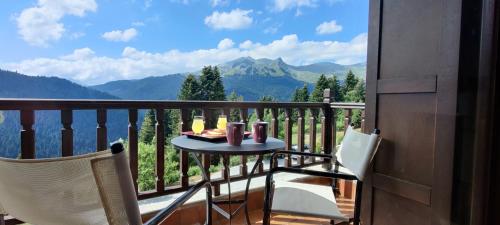 a table and chairs on a balcony with a view of mountains at Ξενοδοχείο ΜΑΓΚΙΩΣΗ in Neraïdochóri