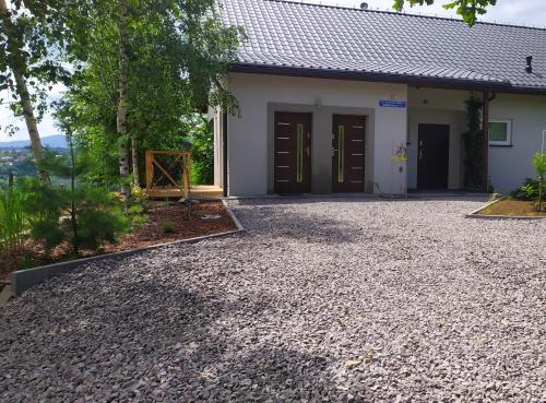 a house with a gravel driveway in front of it at Studio Beskidy in Żywiec