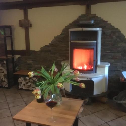 a fireplace with a vase of flowers on a table at Hotel Hoxter Am Jakobsweg in Höxter