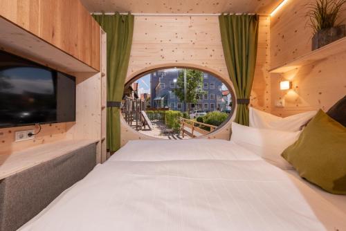 Un dormitorio con una cama grande y una ventana en Zur Post Kümmersbruck Hotel & Tiny Houses en Kümmersbruck