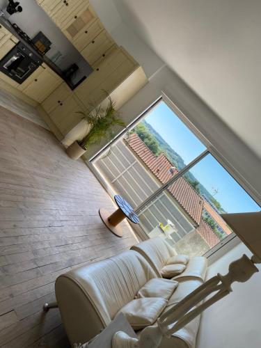 un salon avec un canapé et une grande fenêtre dans l'établissement Appartement de l’abbaye, à Saint-Astier