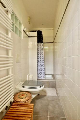 une salle de bain blanche avec toilettes et douche dans l'établissement Maisonnette au centre de Deauville, à Deauville