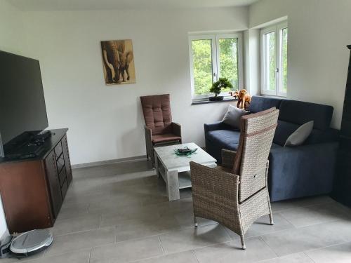 a living room with a blue couch and chairs at Casa Bianka in Fridolfing