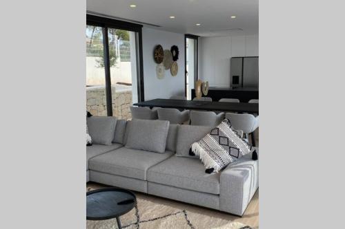 a living room with a gray couch and a table at Villa Rheia in Jávea