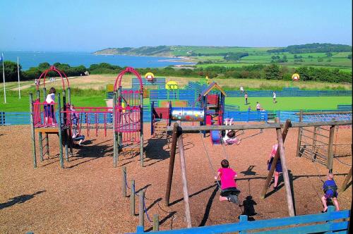 a group of people playing in a playground at Family Holiday Home - Thorness Bay - WIFI in Porchfield