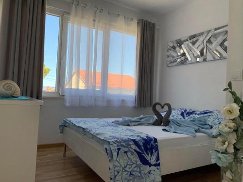 a bedroom with a bed with a large window at Apartments Milica in Mirce