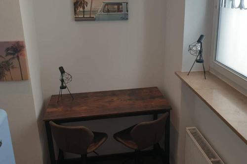 a room with a desk and two chairs and a television at Ferienwohnung Charlotte Seebrise in Friedrichshafen