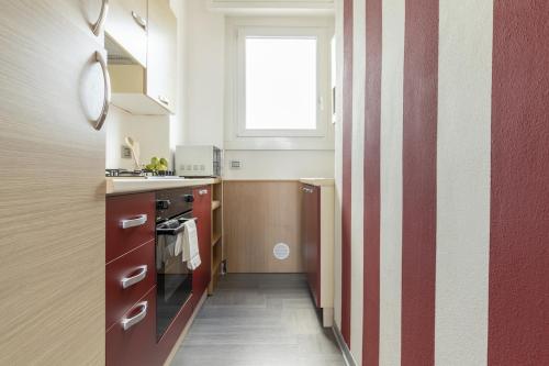 a kitchen with a red and white striped wall at La Terrazza in Castelletto sopra Ticino