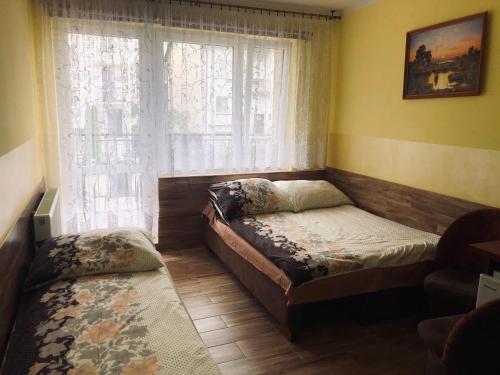 a small bedroom with a bed and a window at Limba II in Łeba