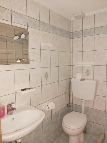 a bathroom with a white toilet and a sink at Eleni's Studios in Nikiana