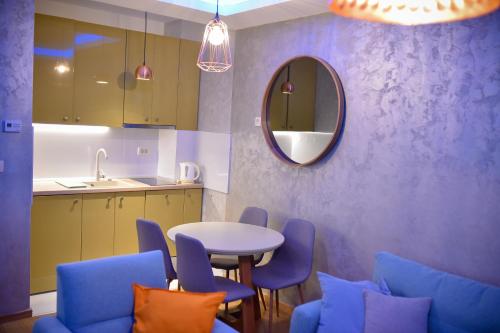 - une cuisine avec une table, des chaises et un miroir dans l'établissement Apartman Obradović, à Zlatibor