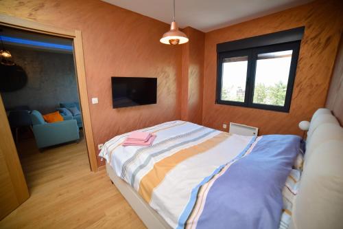 a bedroom with a bed and a tv in it at Mount Inn Obradović in Zlatibor