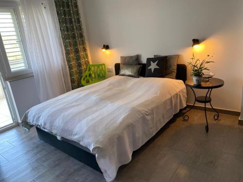 een slaapkamer met een groot bed en een tafel bij Casa Fumica Studio in Kampor
