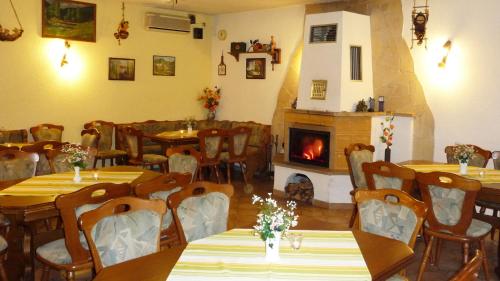 un ristorante con tavoli, sedie e un camino di 4-Bettzimmer Sächsische Schweiz a Mittelndorf
