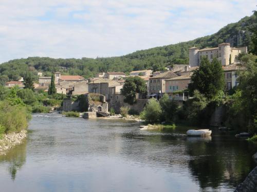a view of a river with a town in the background at Couleurs du Sud in Vallon-Pont-dʼArc