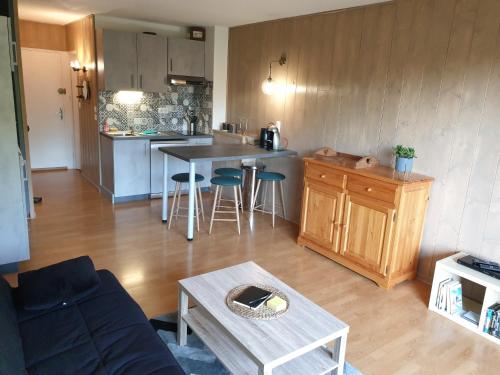 cocina y sala de estar con mesa y sofá en Studio refait à neuf en Saint-Jean-Saint-Nicolas