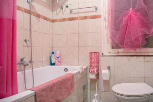 ein Badezimmer mit einem rosa Duschvorhang und einem WC in der Unterkunft FABOULOUS apartment in Belgrad