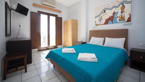 Un dormitorio con una cama azul con toallas. en Villa Stella, en Fira