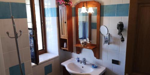 a bathroom with a sink and a mirror at Villa Sant’Uberto Country Inn in Radda in Chianti