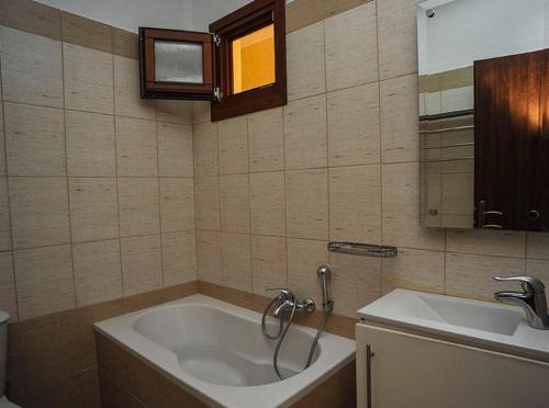 a bathroom with a bath tub and a sink at Guesthouse Syntrofia in Psarádes