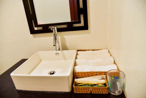a bathroom with a sink and a basket of towels at Nohana Hotel in Mui Ne