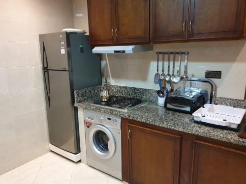 uma cozinha com um frigorífico e uma máquina de lavar roupa em Résidence EL AMAL em Martil
