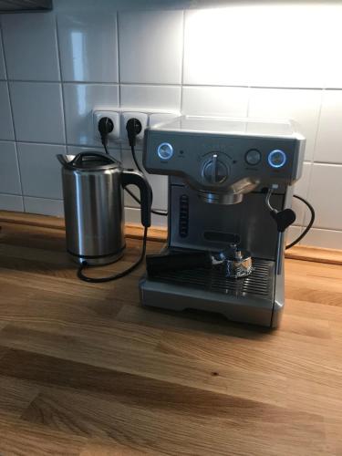 a black coffee maker and a pot on a floor at Apartmány v pivovaru in Kašperské Hory