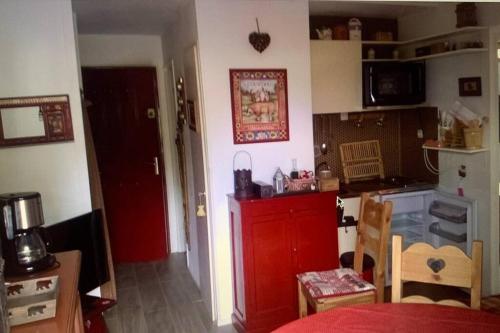 a kitchen with a red cabinet in a room at Appartement T3 Cosy St Gervais les Bains -Grattague in Mémontel