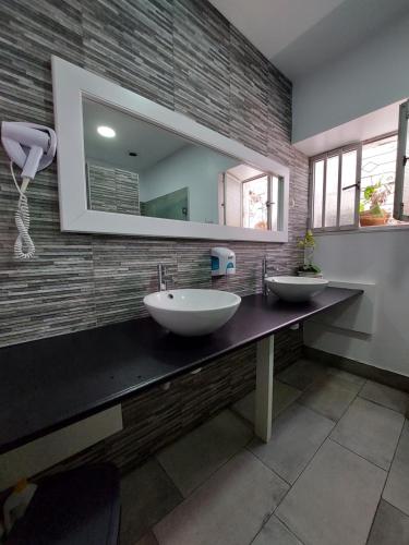 a bathroom with two sinks and a mirror at Aloha Hostel in Portimão