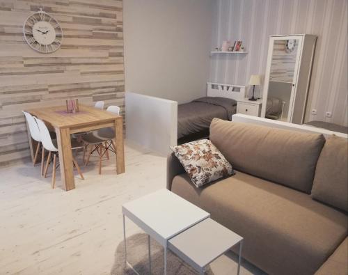 ein Wohnzimmer mit einem Sofa und einem Tisch in der Unterkunft Apartman Park in Subotica