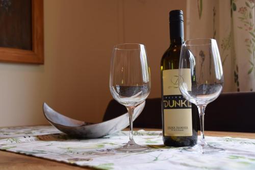 a bottle of wine and two wine glasses on a table at Ferienhaus Jagafranzl in Gnas
