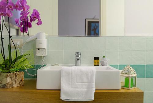 - un lavabo dans la salle de bains avec une serviette blanche sur un comptoir dans l'établissement Country House Torrenera, à Morro dʼOro