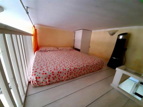 a bedroom with a bed with a red comforter at Flat Low cost in Sperlonga