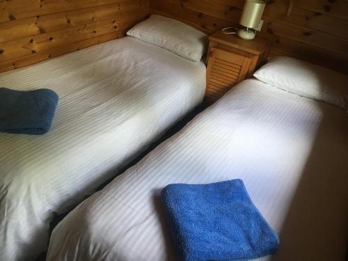 two beds sitting next to each other in a room at Chalet 2 in Tyndrum