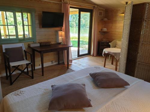 Dormitorio con cama, escritorio y TV en Les Iris - Domaine du Lac de la Vallée, en La Roquette-sur-Siagne