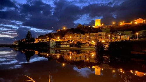 a city lit up at night with a body of water at Villa Giadel in Menfi