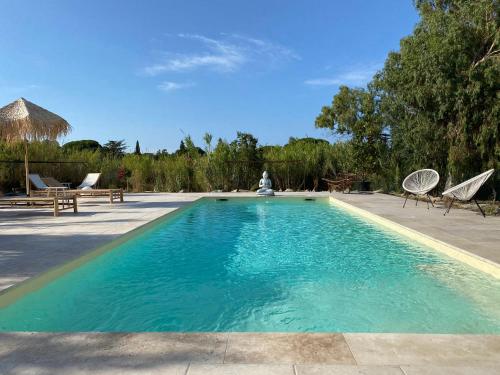 basen z niebieską wodą, krzesłami i drzewami w obiekcie Residence Paolina w Calvi