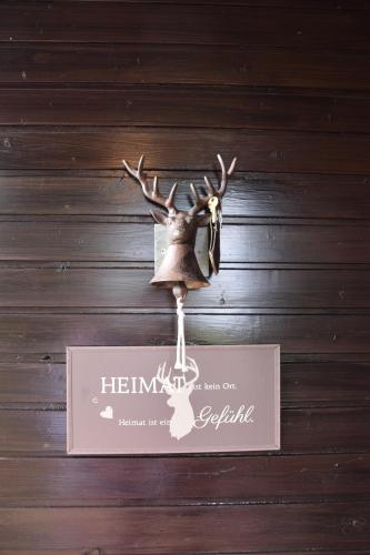 a bell hanging on a wall with a sign at Ferienhaus Jagafranzl in Gnas