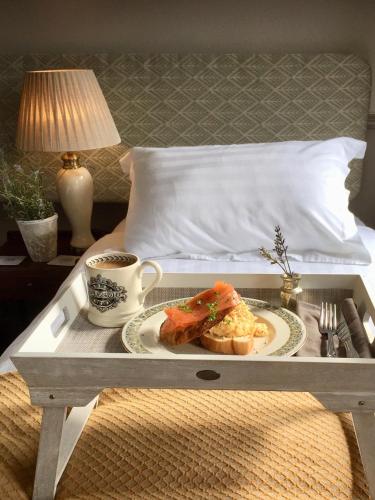 a tray with a plate of food and a cup of coffee at The Bridge House in Bridport