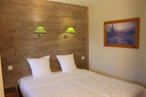 um quarto com uma cama com 2 candeeiros na parede em Résidence Christiana 408 Clés Blanches Courchevel em Courchevel