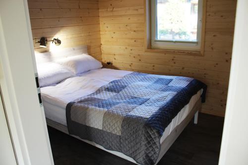 a bedroom with a bed in a wooden room at luludomki in Mielenko