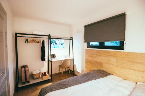 um quarto com uma cama, uma secretária e uma janela em Kub House em Bacău
