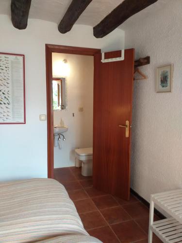 a bedroom with a bed and a bathroom with a toilet at Casa Rural Boletas in Loporzano