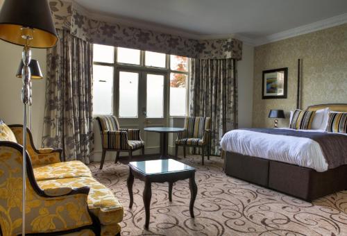 a hotel room with a bed and a table and chairs at Pontlands Park Hotel in Chelmsford