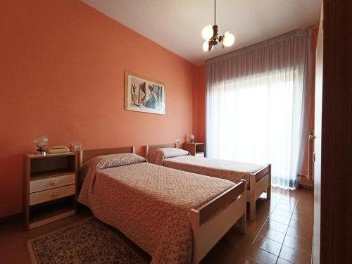 two beds in a room with orange walls and a window at Hotel Santa Maria Del Bagno in Pesche