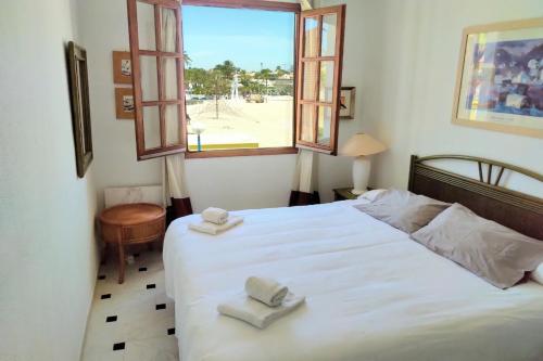 1 dormitorio con 1 cama blanca y 2 toallas en Shoal Apartamentos, en Playas de Orihuela