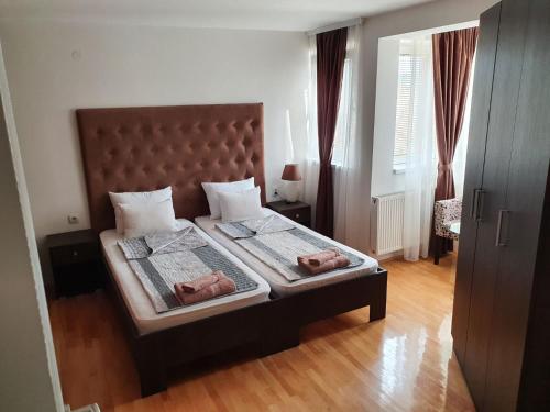 a bedroom with a bed with two donuts on it at Family Apartments in Zaječar